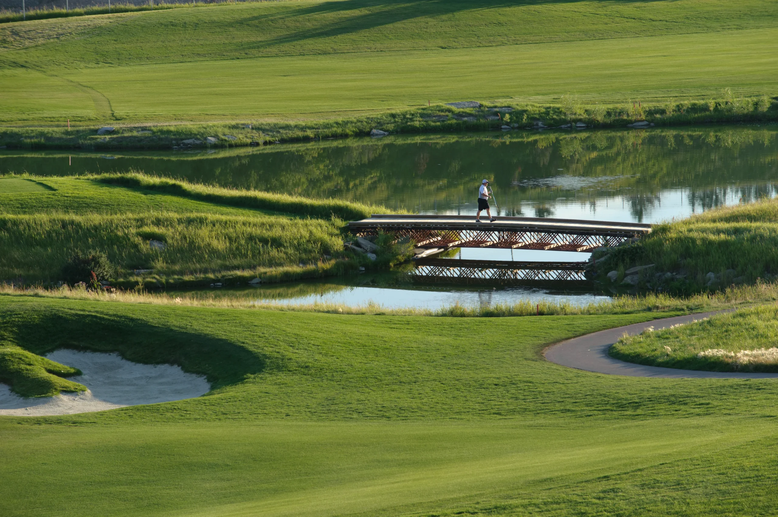 a golf course bridge and someone walking across it